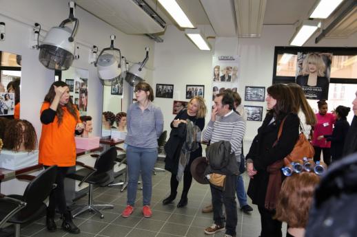 Une élève de l'atelier coiffure donne des explications aux visiteurs.